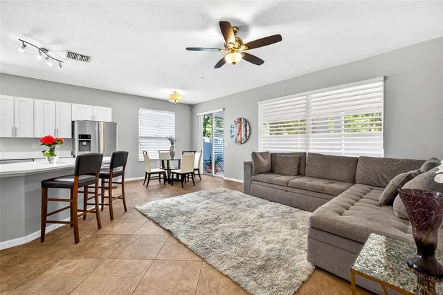 a kitchen with stainless steel appliances granite countertop a dining table chairs refrigerator microwave and cabinets