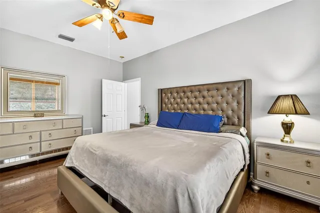 a bed sitting in a bedroom next to a window and a chandelier