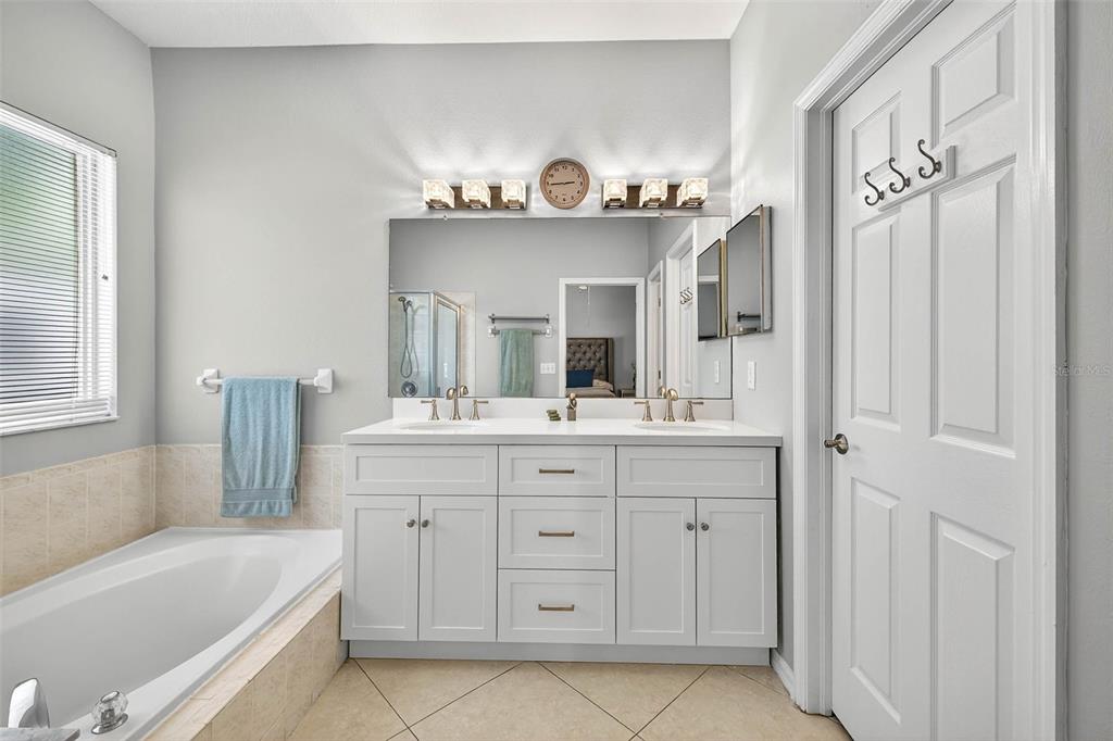 8853 Cypress Hammock Drive Tampa, FL 33614 - Photo 22 of 41 a bathroom with a sink a mirror a vanity and bathtub