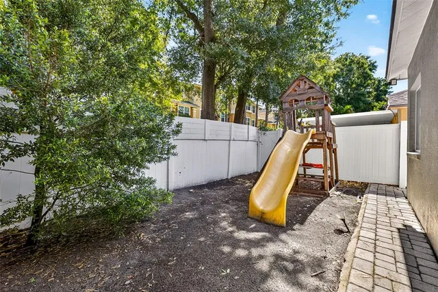 a view of a yard with potted plants and a large tree