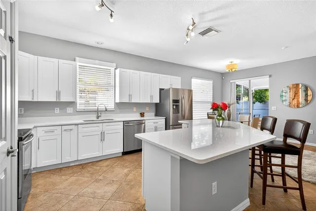 a kitchen with white cabinets and white appliances
