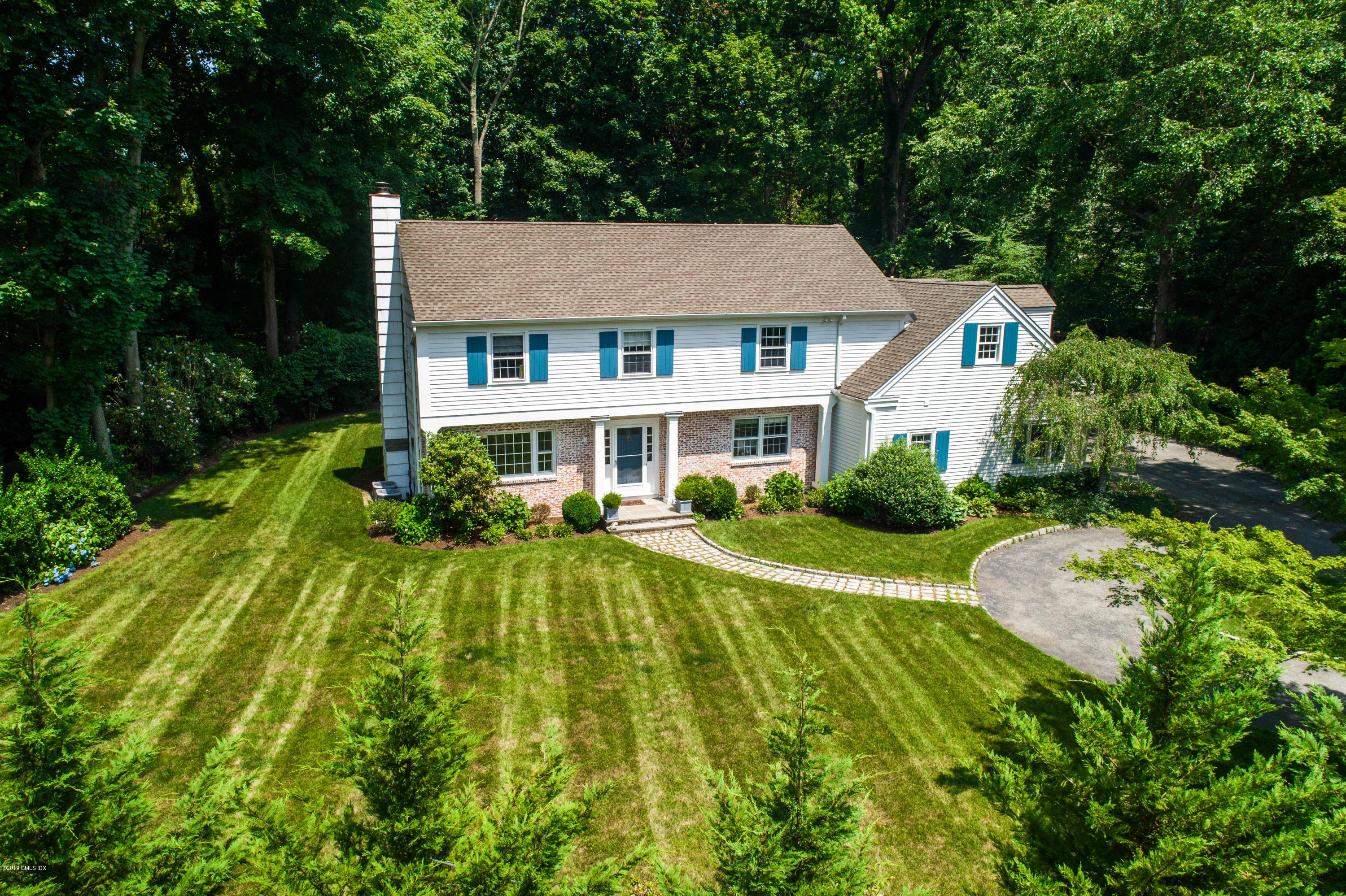 58 Indian Head Road Riverside, CT 06878 - Photo 1 of 33 a front view of a house with a yard table and chairs