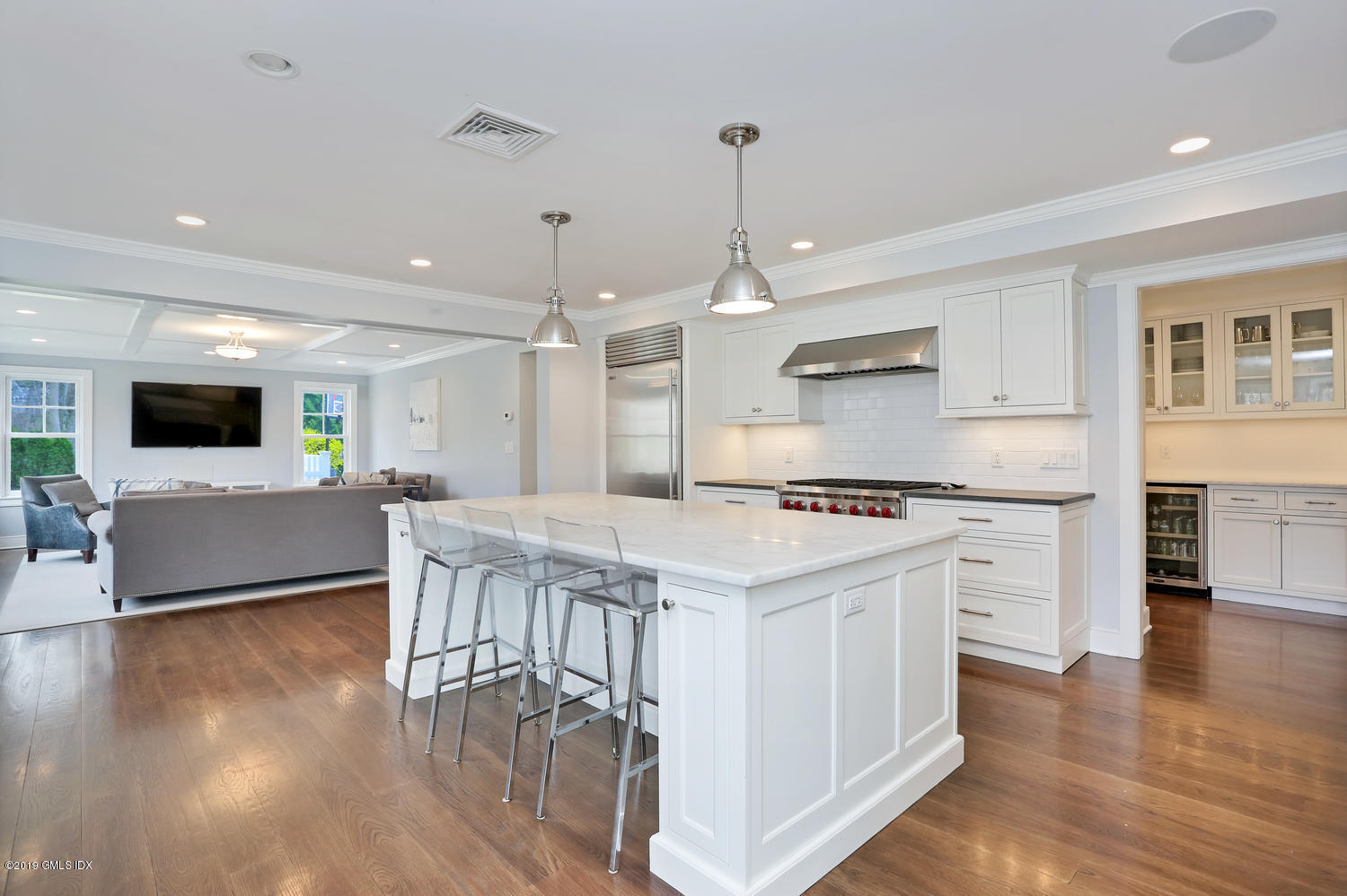 58 Indian Head Road Riverside, CT 06878 - Photo 11 of 33 a large kitchen with kitchen island a stove a sink a refrigerator and a dining table with wooden floor