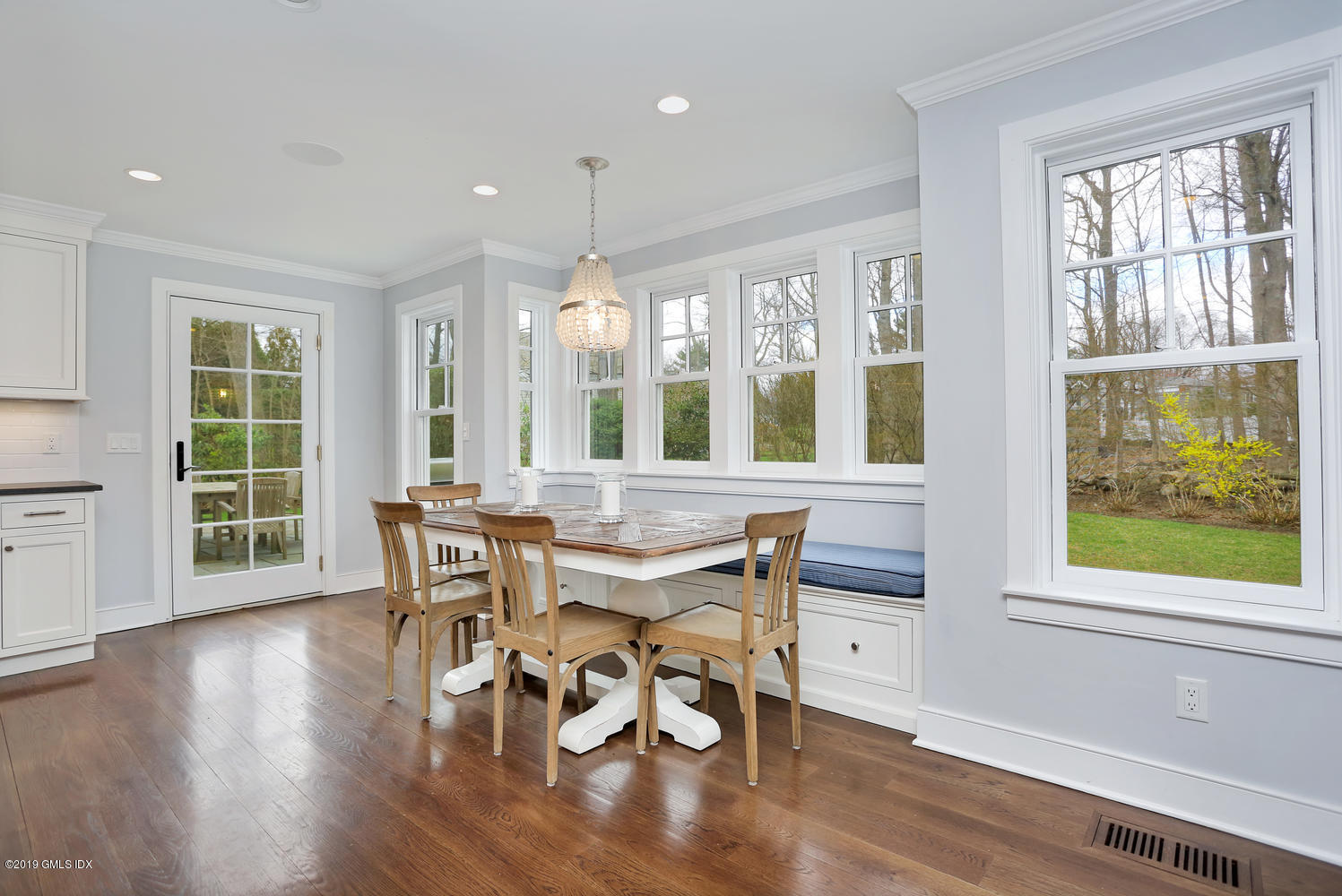 58 Indian Head Road Riverside, CT 06878 - Photo 12 of 33 a dining room with wooden floor a chandelier a glass table and chairs