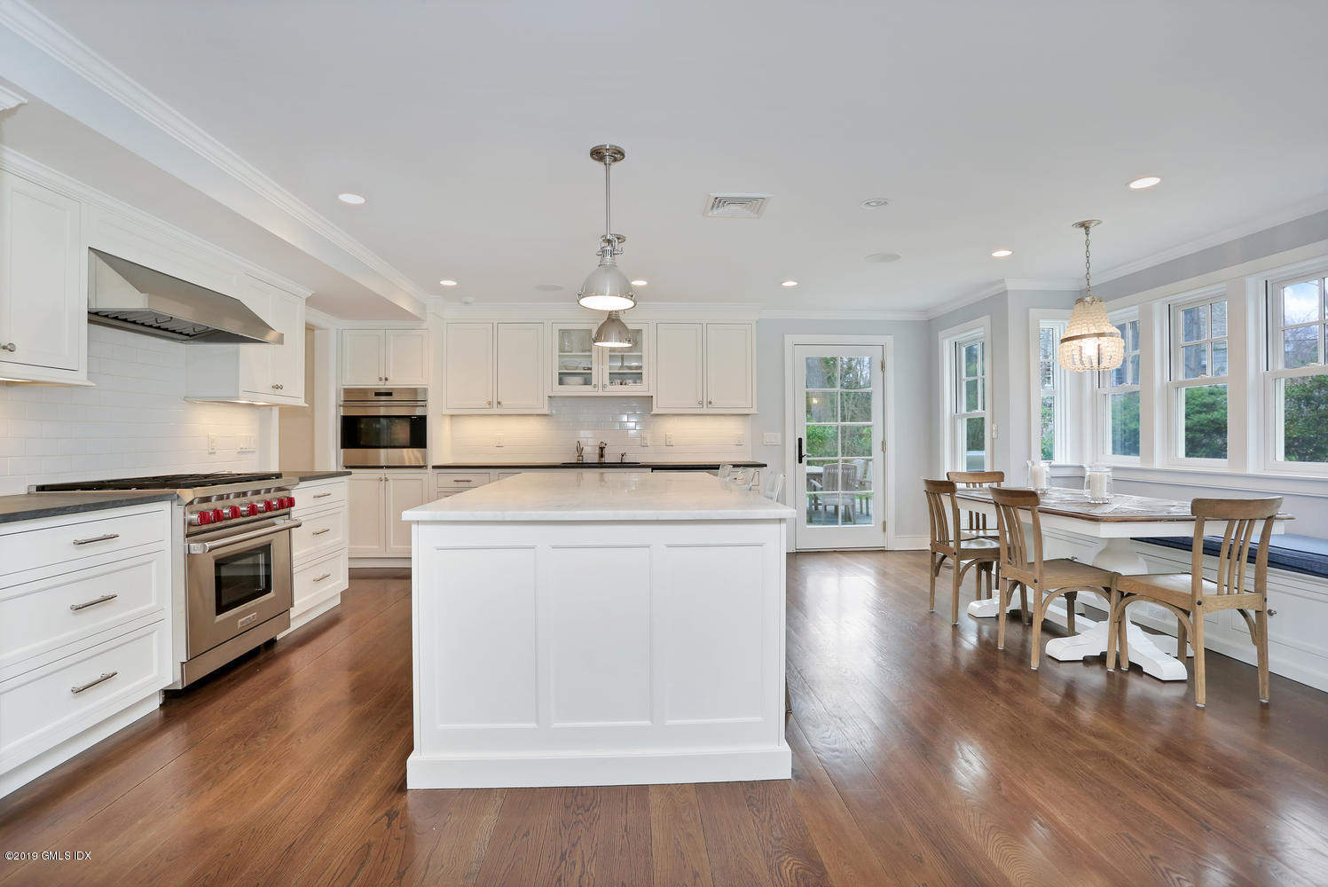 58 Indian Head Road Riverside, CT 06878 - Photo 9 of 33 a kitchen with stainless steel appliances kitchen island granite countertop a stove a sink a refrigerator and white cabinets with wooden floor