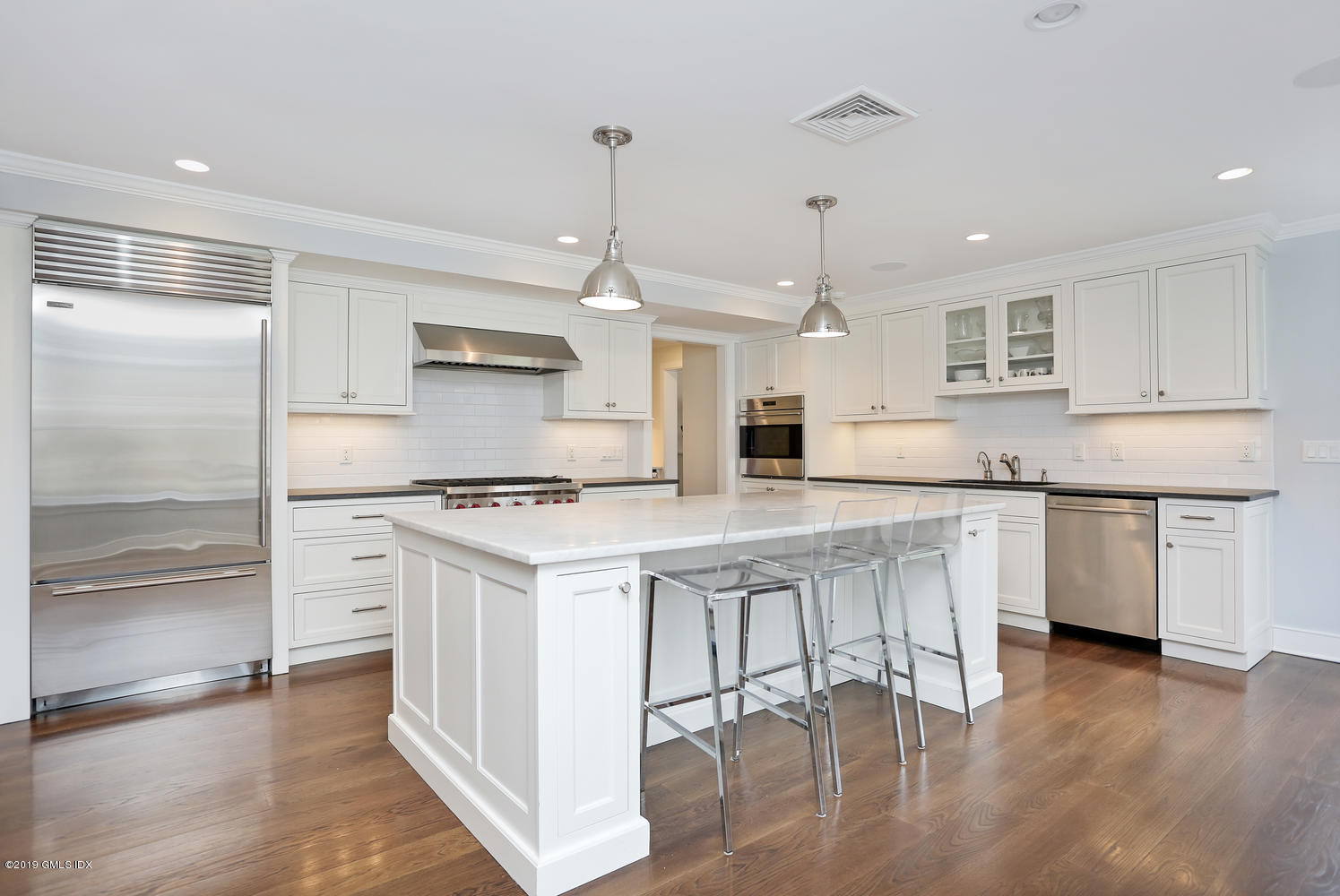 58 Indian Head Road Riverside, CT 06878 - Photo 10 of 33 a kitchen with stainless steel appliances granite countertop a white stove top oven and a chandelier