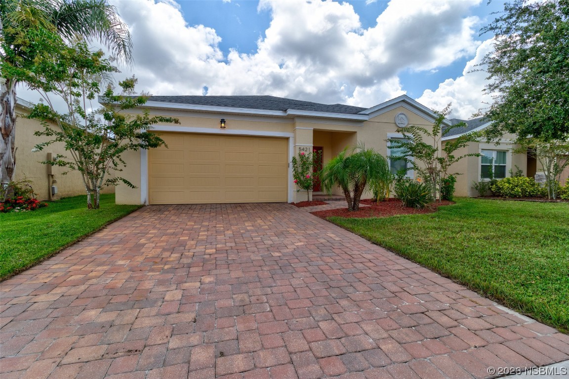 5421 Estero Loop Port Orange, FL 32128 - Photo 4 of 30 a view of a white house next to a yard and potted plants