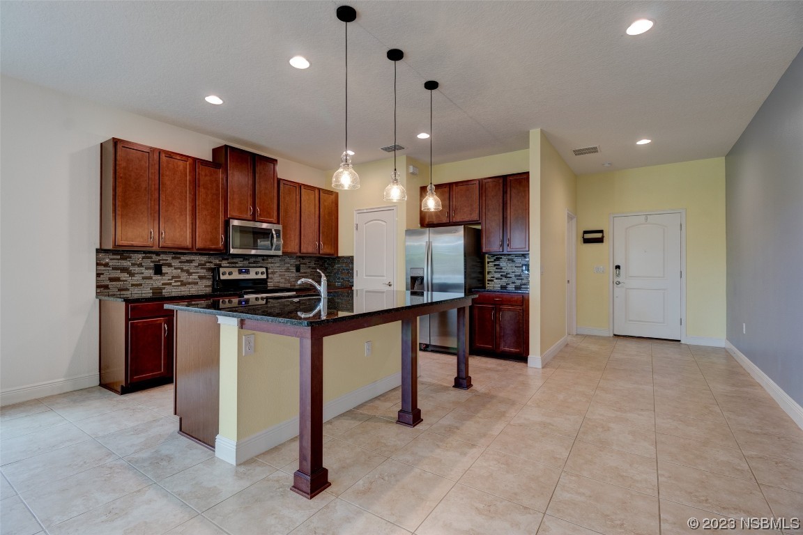 5421 Estero Loop Port Orange, FL 32128 - Photo 5 of 30 a kitchen with stainless steel appliances kitchen island granite countertop a refrigerator and a stove top oven