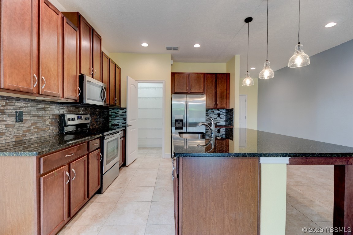 5421 Estero Loop Port Orange, FL 32128 - Photo 7 of 30 a kitchen with kitchen island granite countertop a refrigerator and a sink
