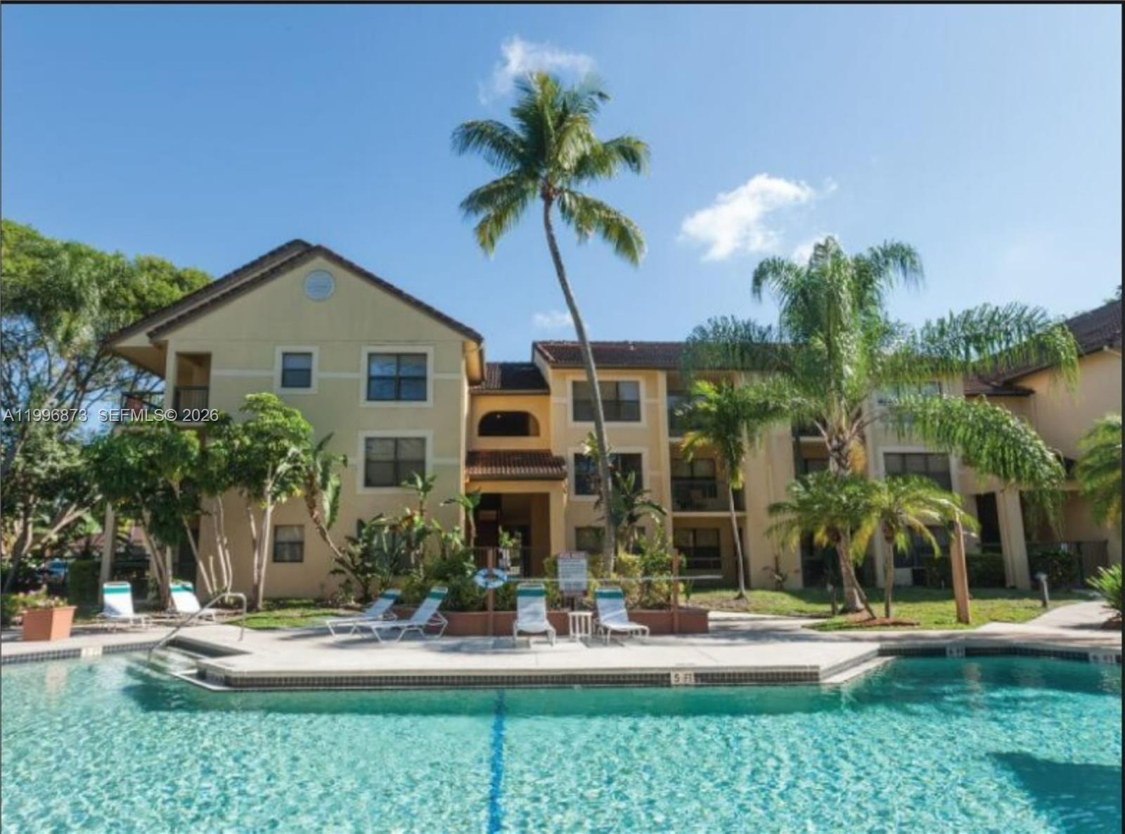 4581 West McNab Road, Unit 17 Pompano Beach, FL 33069 - Photo 2 of 12 a front view of a house with swimming pool and glass windows