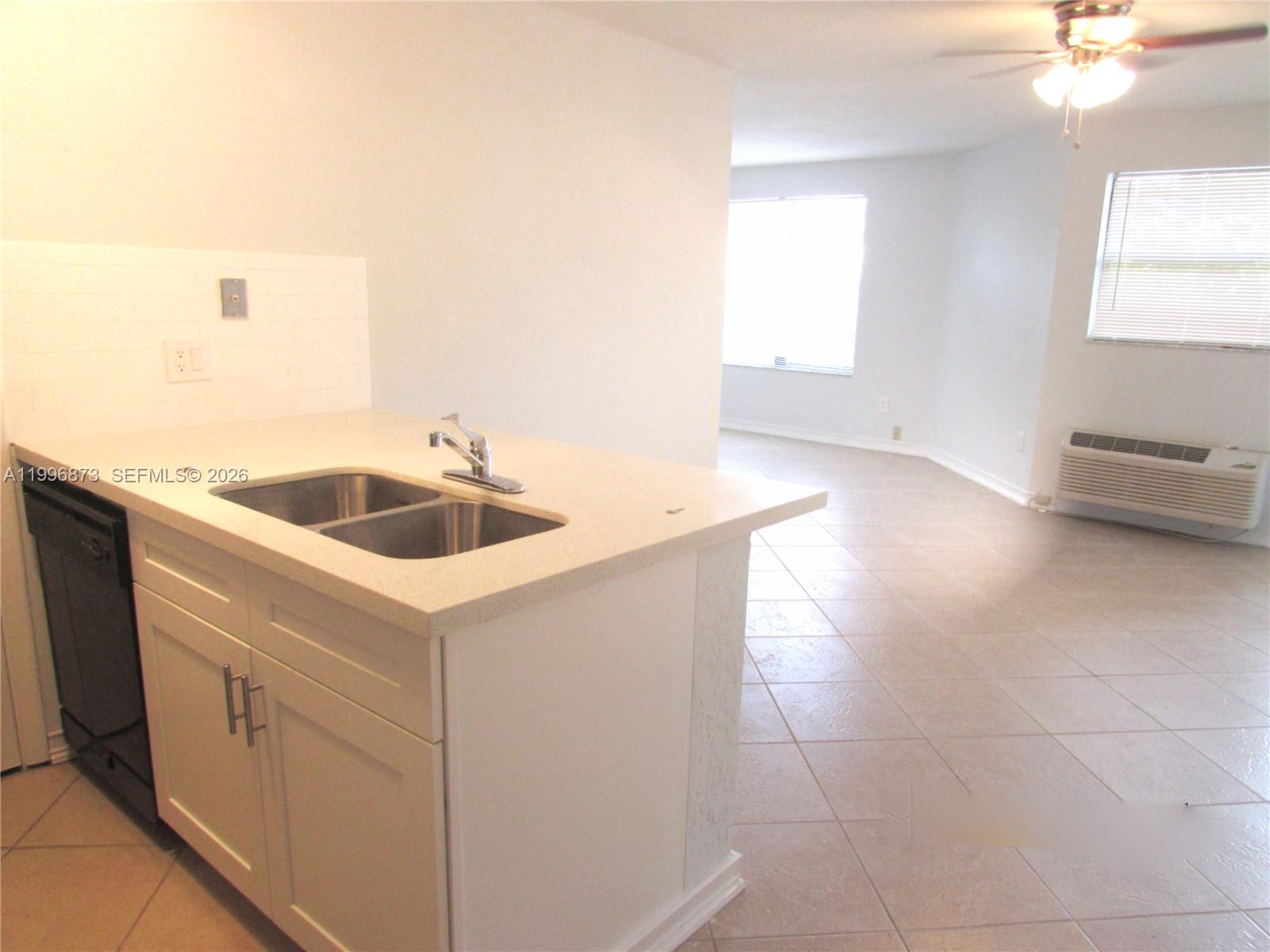 4581 West McNab Road, Unit 17 Pompano Beach, FL 33069 - Photo 3 of 12 a kitchen with a sink cabinets and window