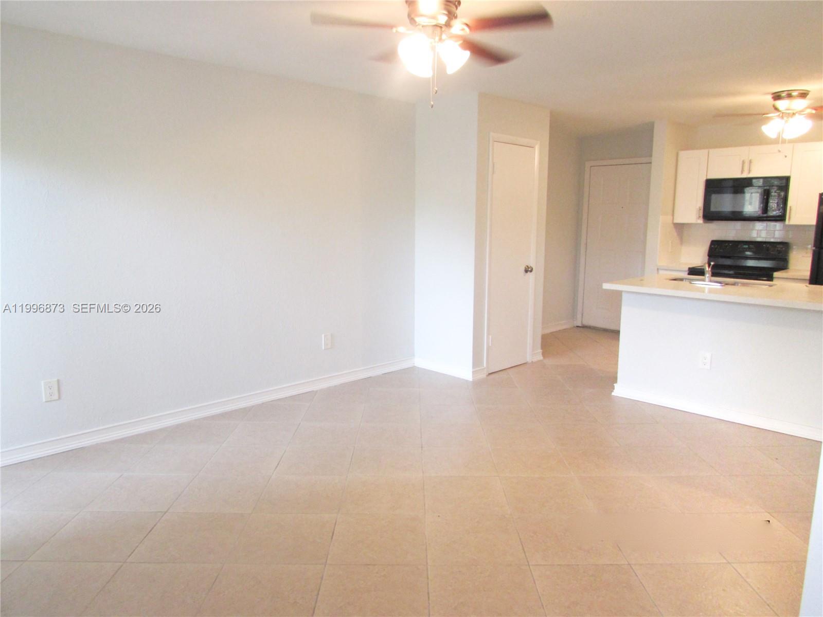 4581 West McNab Road, Unit 17 Pompano Beach, FL 33069 - Photo 6 of 12 a view of a kitchen with microwave and cabinets