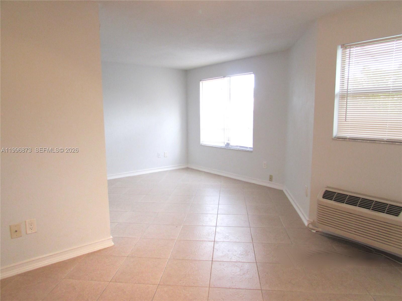 4581 West McNab Road, Unit 17 Pompano Beach, FL 33069 - Photo 8 of 12 an empty room with windows