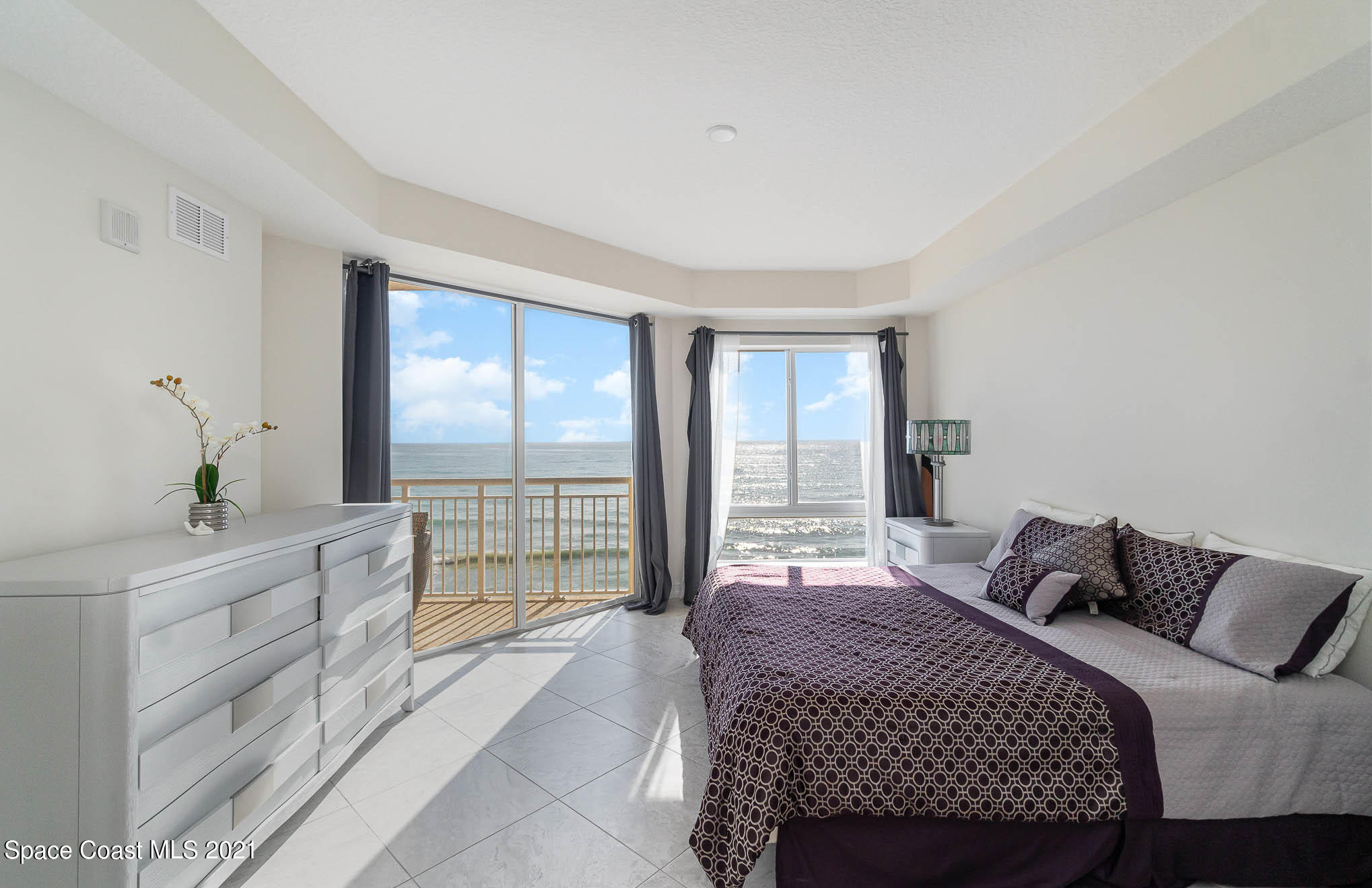 1045 Florida A1A, Unit 503 Satellite Beach, FL 32937 - Photo 12 of 23 a bedroom with a large bed and a chandelier