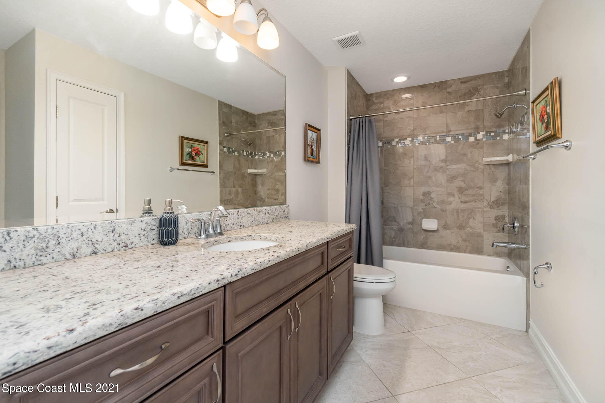 1045 Florida A1A, Unit 503 Satellite Beach, FL 32937 - Photo 17 of 23 a bathroom with a granite countertop sink toilet and shower