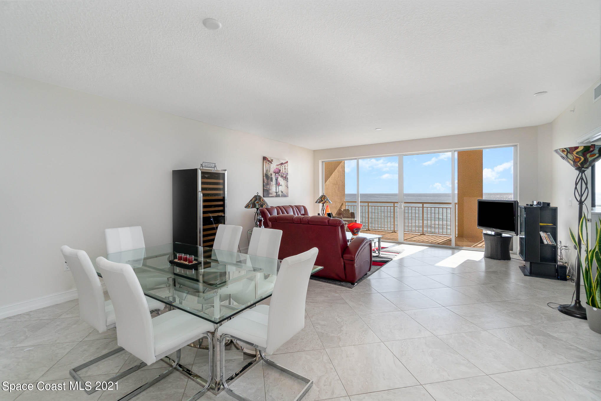 1045 Florida A1A, Unit 503 Satellite Beach, FL 32937 - Photo 7 of 23 a living room with furniture a flat screen tv and a large window