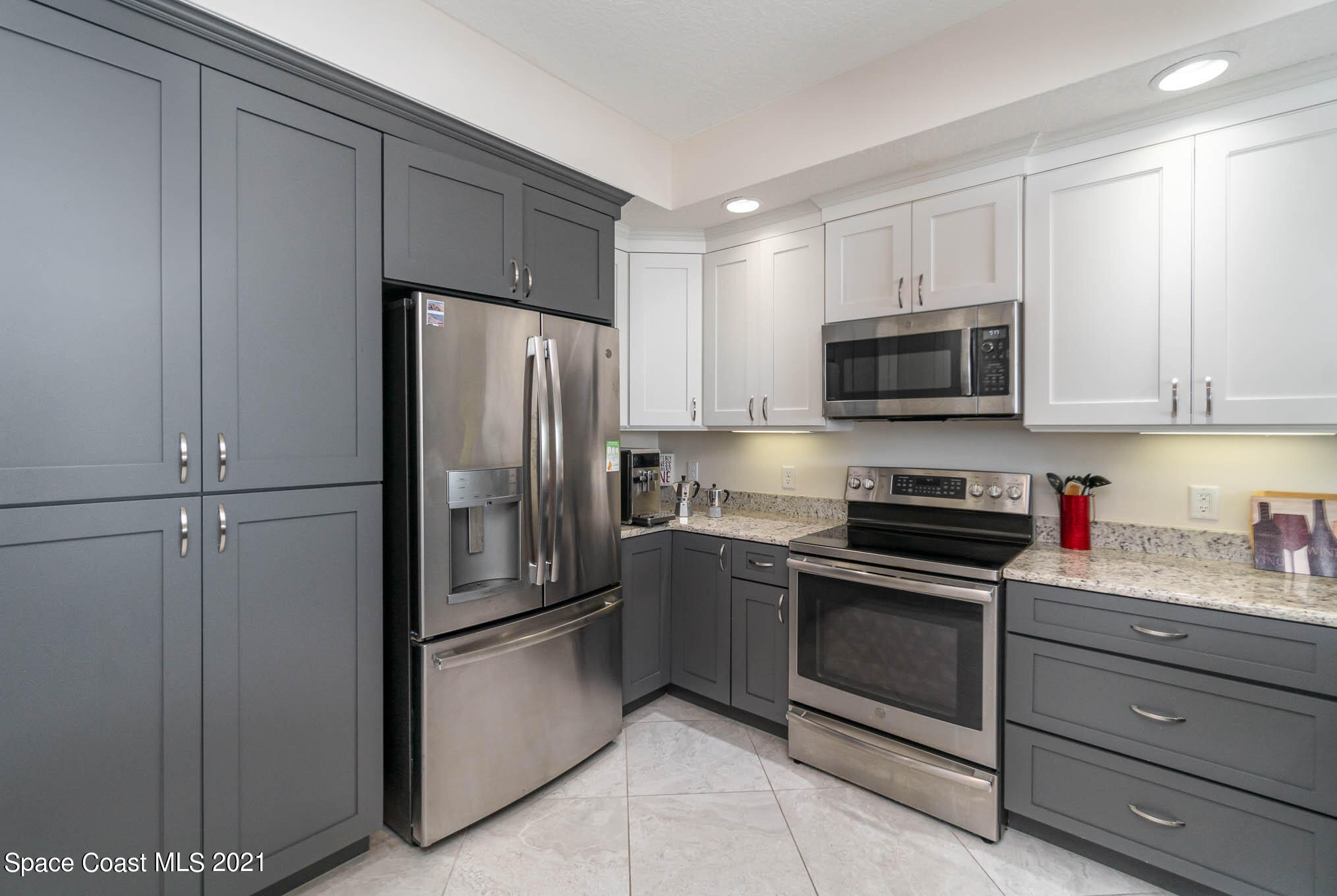1045 Florida A1A, Unit 503 Satellite Beach, FL 32937 - Photo 10 of 23 a kitchen with stainless steel appliances granite countertop a refrigerator and a stove top oven