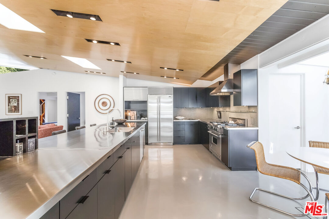 2538 Hutton Drive Beverly Hills, CA 90210 - Photo 23 of 63 a large kitchen with kitchen island a large counter top space a sink stainless steel appliances and cabinets