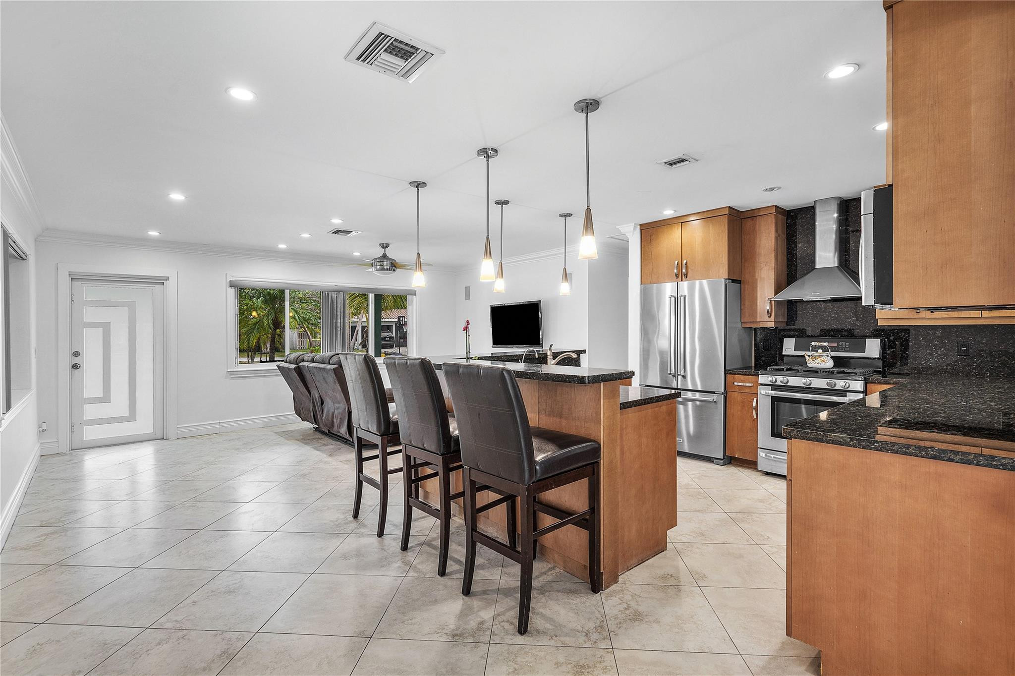 290 Northeast 29th Street Boca Raton, FL 33431 - Photo 8 of 48 a kitchen with stainless steel appliances kitchen island granite countertop a stove a sink a refrigerator and a dining table