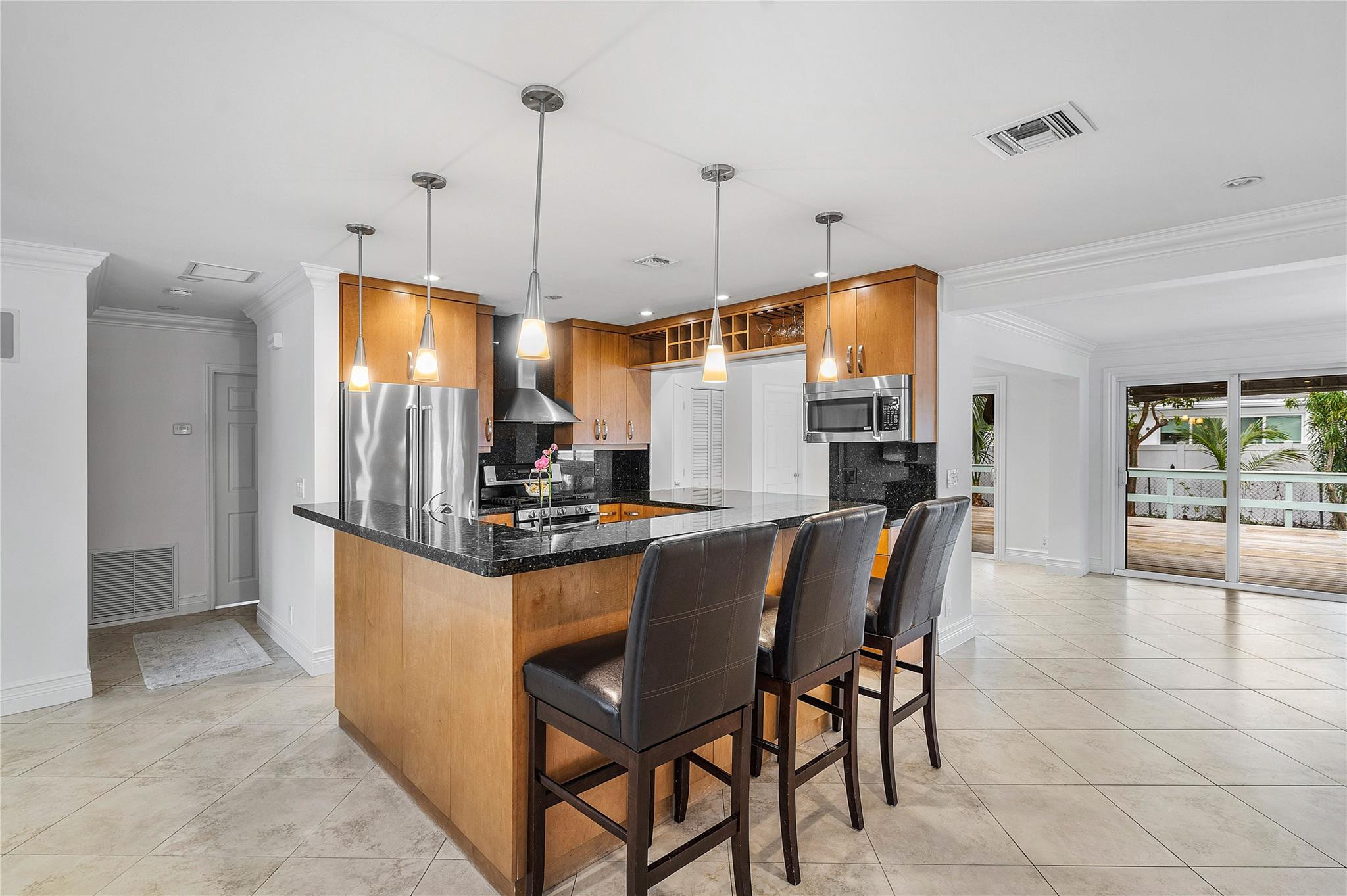 290 Northeast 29th Street Boca Raton, FL 33431 - Photo 10 of 48 a kitchen with stainless steel appliances granite countertop a stove a refrigerator a oven a sink with a dining table and chairs