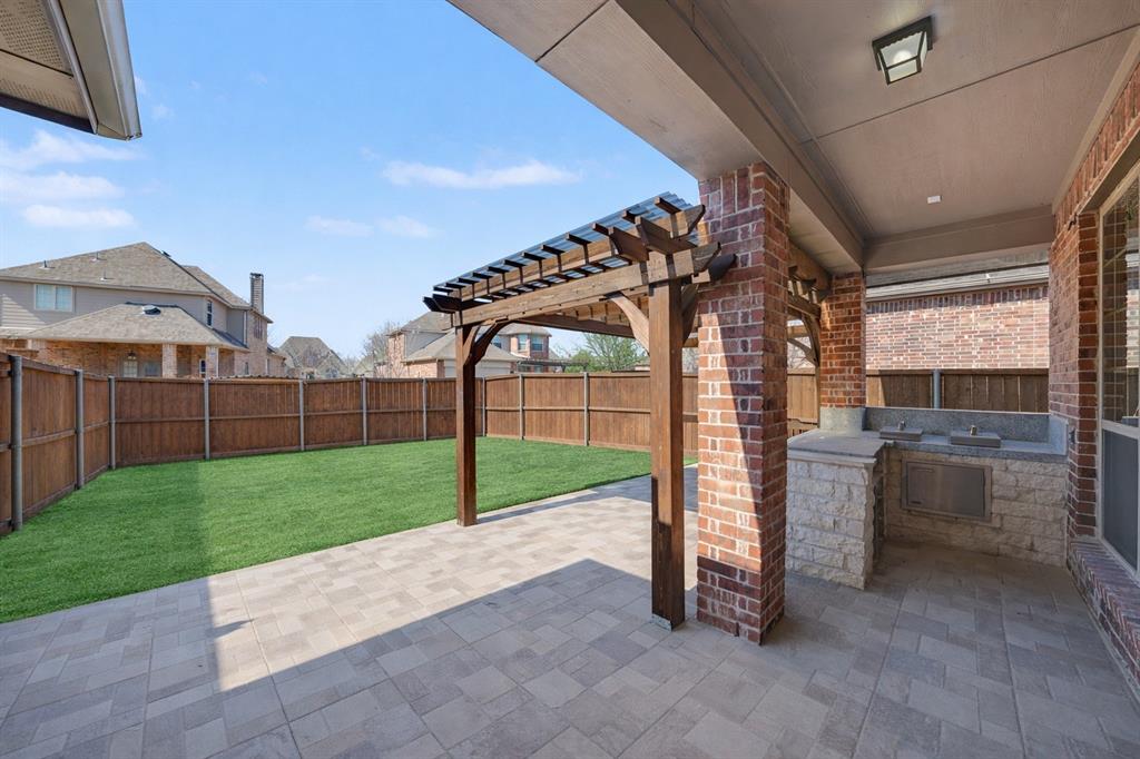 2243 Big Valley Road Allen, TX 75013 - Photo 17 of 19 Covered patio with paver flooring, integrated outdoor kitchen, and a wooden pergola