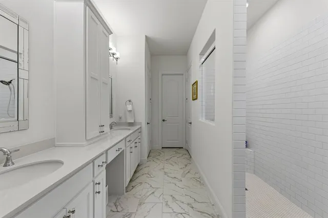 a spacious bathroom with a double vanity sink toilet mirror and bathtub