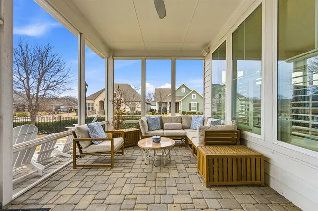 a living room with patio furniture and a floor to ceiling window