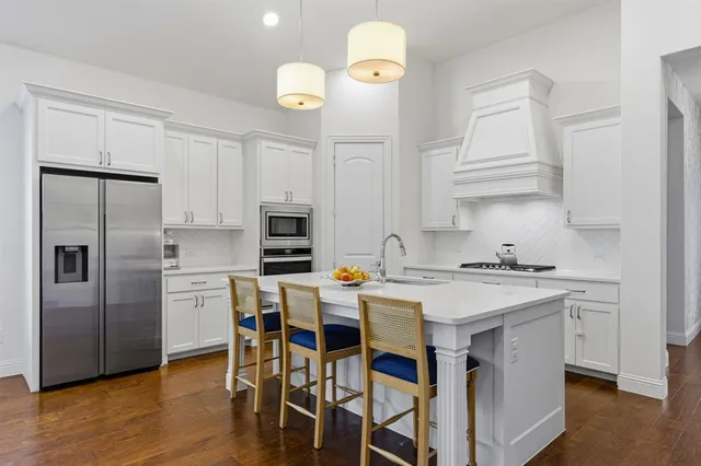 a kitchen with stainless steel appliances a stove a sink island and a refrigerator