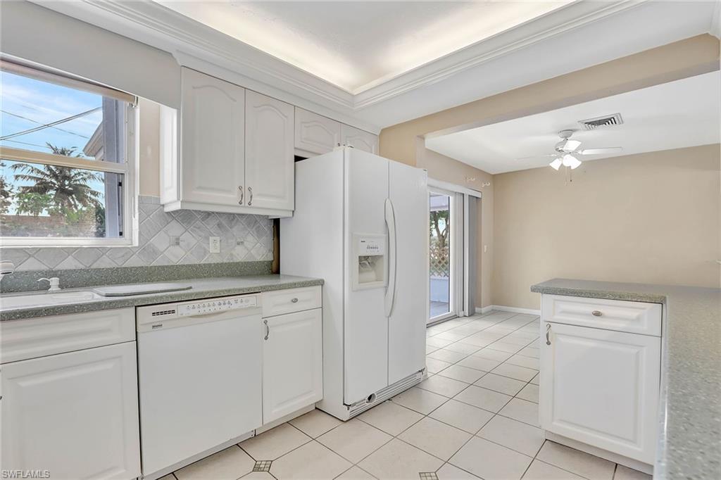 4656 Capri Drive Naples, FL 34103 - Photo 5 of 18 a kitchen with white cabinets and white appliances