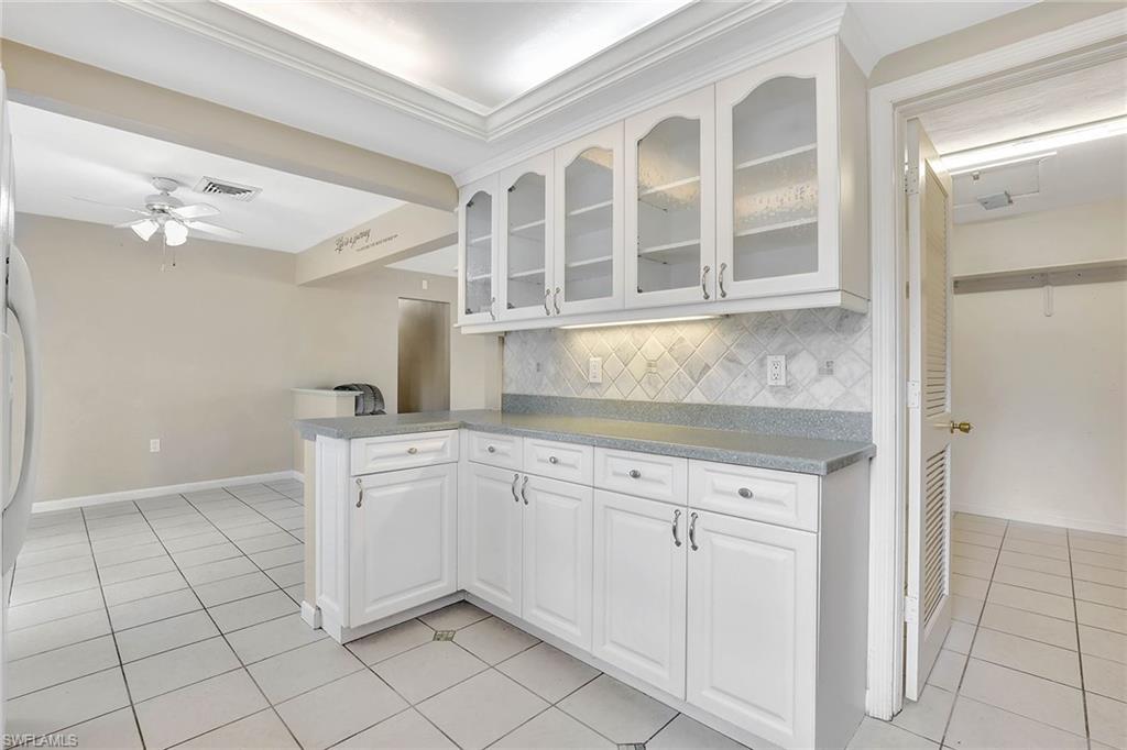 4656 Capri Drive Naples, FL 34103 - Photo 6 of 18 a kitchen with white cabinets and sink