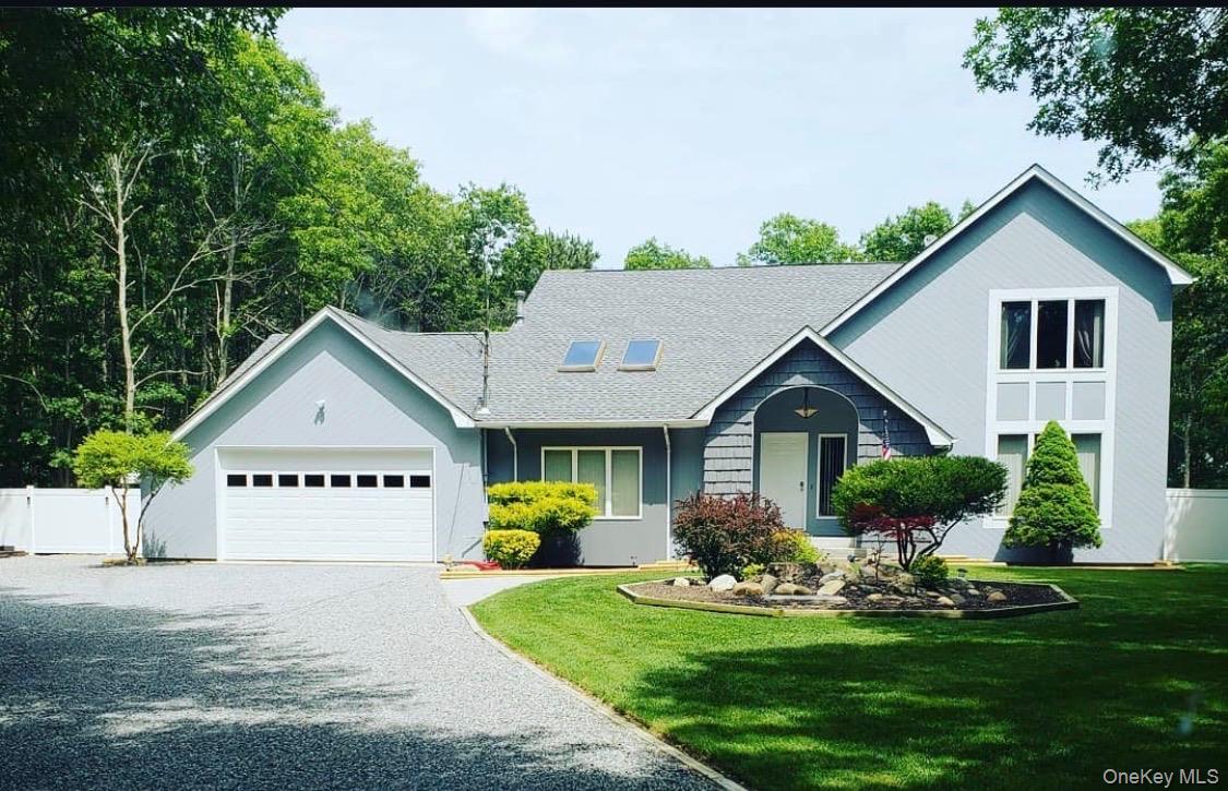 View of front of property with gravel driveway and an attached garage