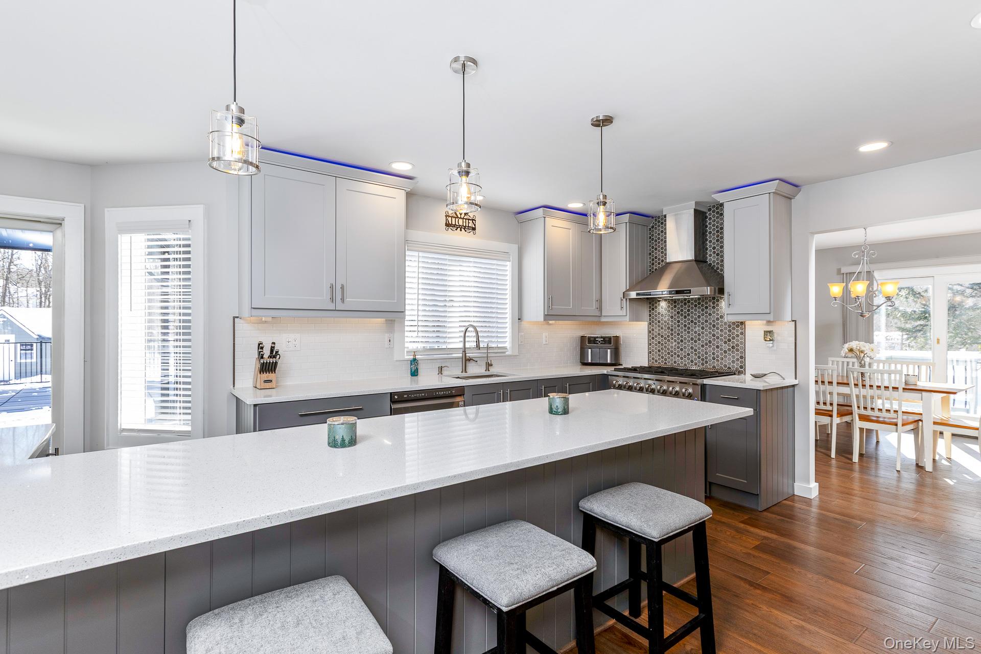 503 Wading River Road Manorville, NY 11949 - Photo 12 of 45 Kitchen featuring hanging light fixtures, gray cabinetry, a breakfast bar, a chandelier, and healthy amount of natural light