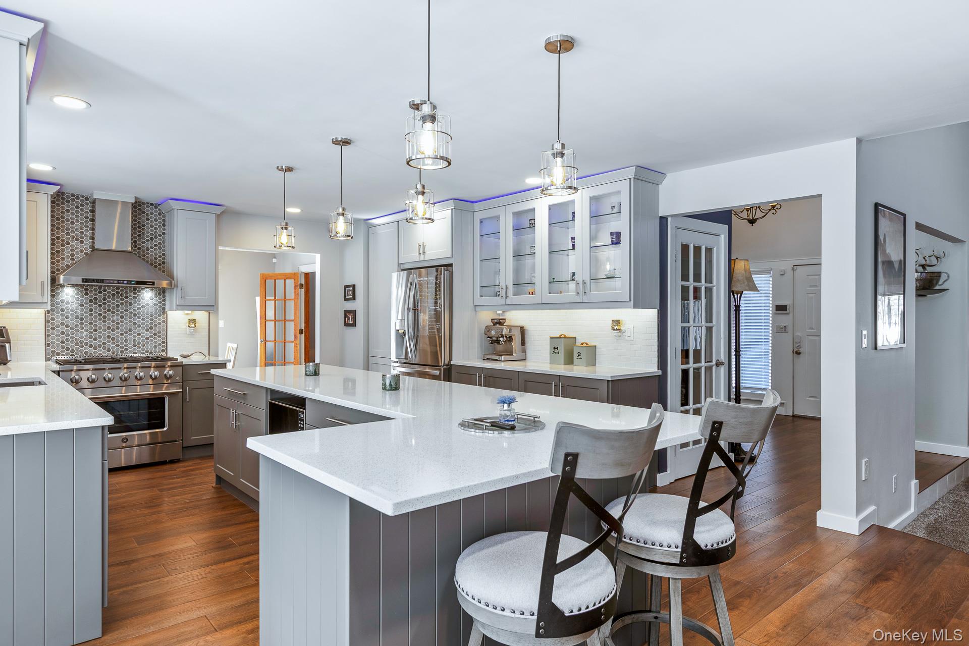 503 Wading River Road Manorville, NY 11949 - Photo 15 of 45 Kitchen featuring gray cabinetry, backsplash, stainless steel appliances, light stone counters, and recessed lighting