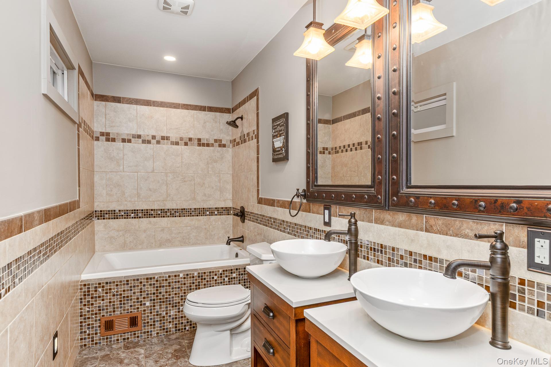 503 Wading River Road Manorville, NY 11949 - Photo 23 of 45 Bathroom with tile walls, double vanity, and tiled shower / bath combo