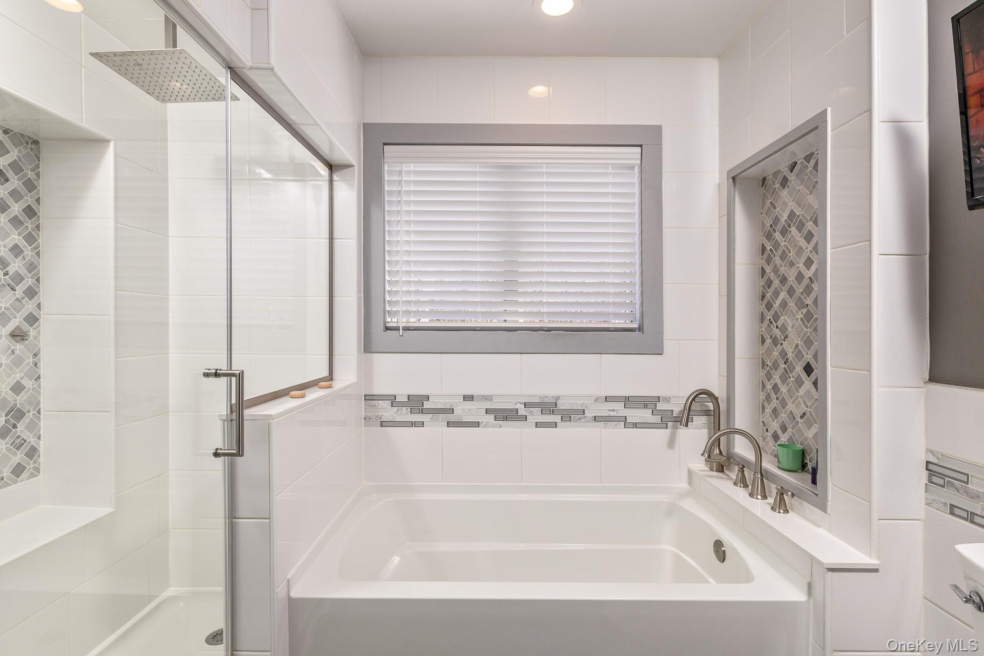 503 Wading River Road Manorville, NY 11949 - Photo 28 of 45 Full bath featuring a stall shower, a bath, and tile walls