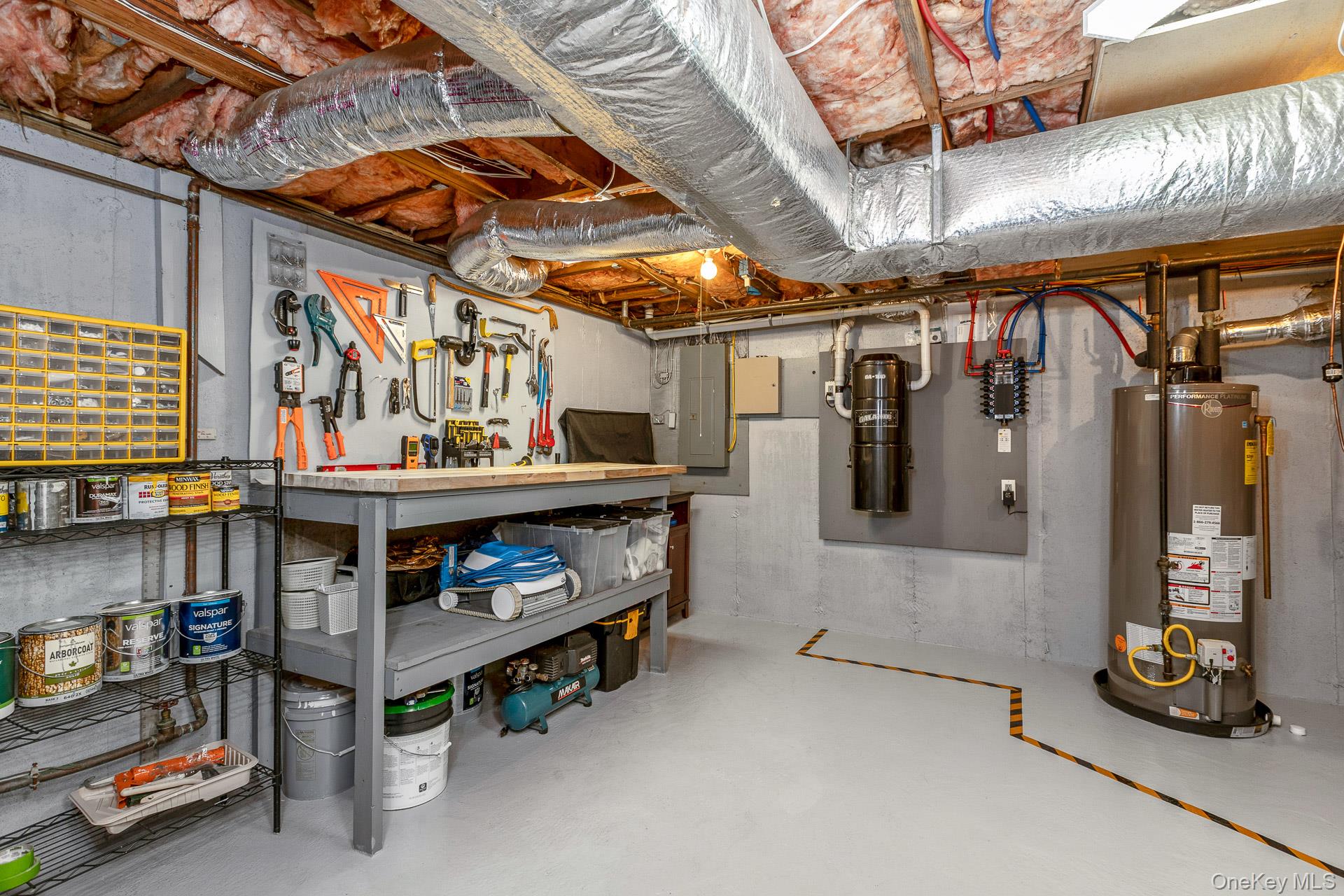 503 Wading River Road Manorville, NY 11949 - Photo 36 of 45 Unfinished basement with a workshop area, water heater, and electric panel