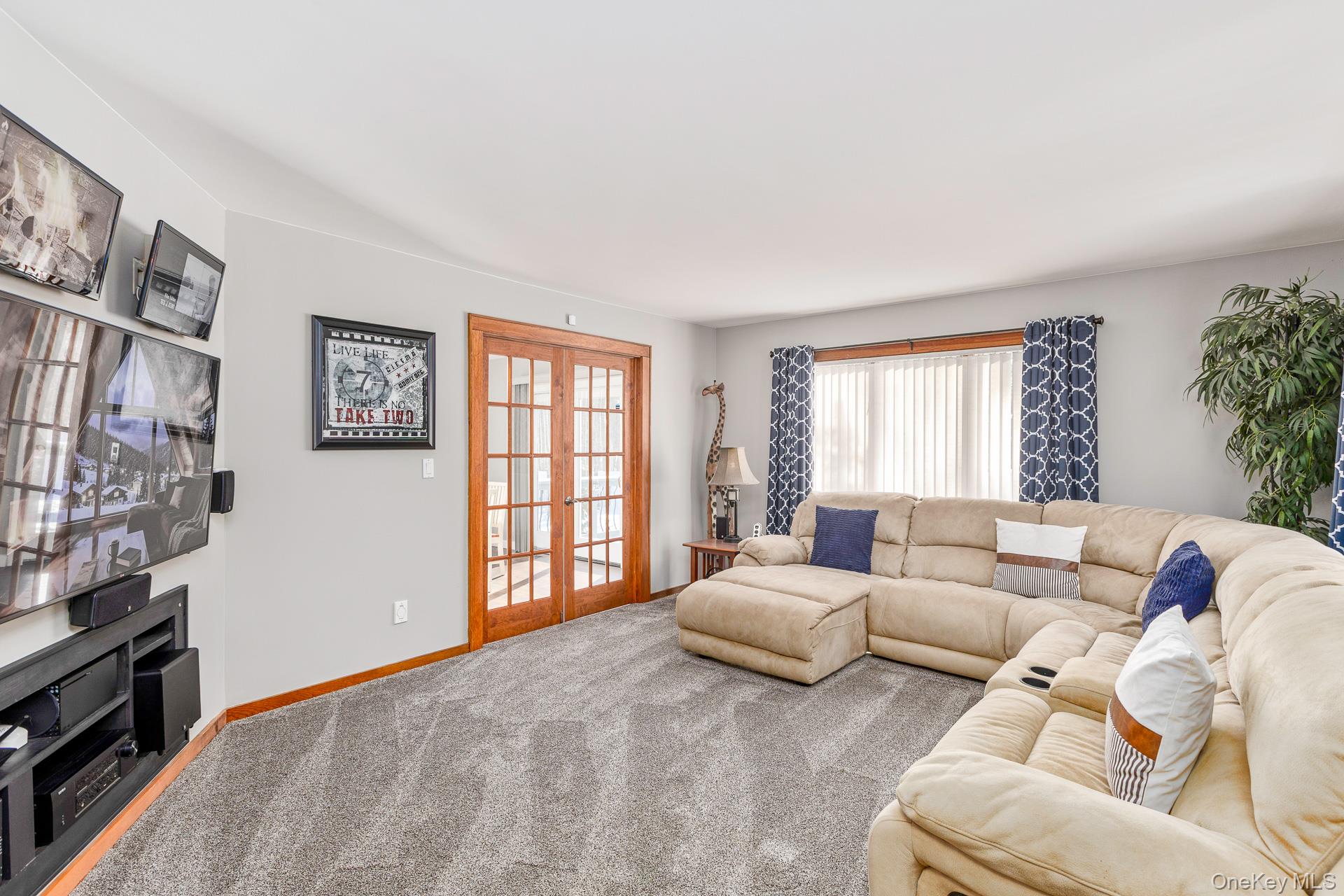 503 Wading River Road Manorville, NY 11949 - Photo 7 of 45 Living area with french doors and carpet floors