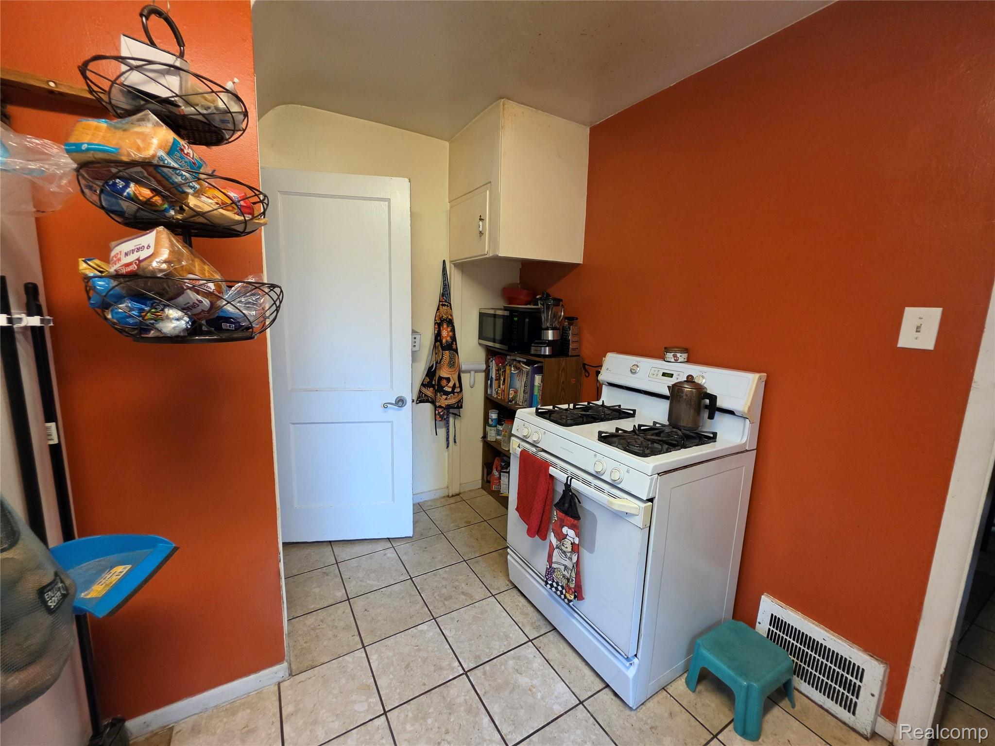 15832 Griggs Street Detroit, MI 48238 - Photo 13 of 24 Kitchen area featuring ceramic tile flooring, a white gas range, and a white interior door