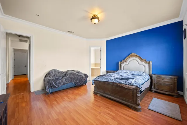 a bedroom with a bed and wooden floor
