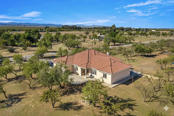 an aerial view of a house with a yard and lake view