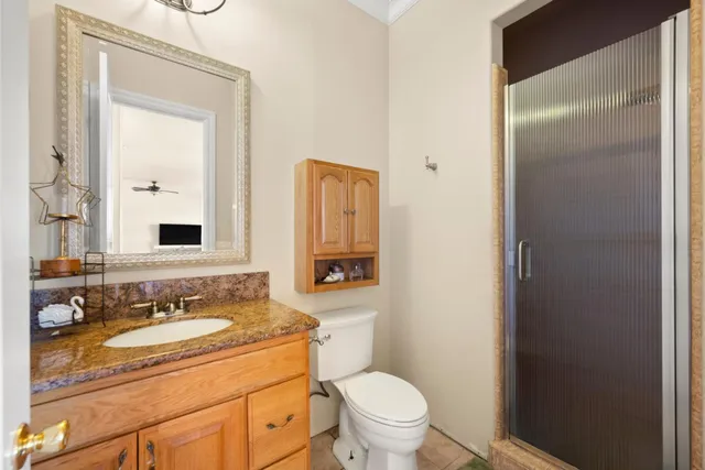 a bathroom with a granite countertop sink toilet mirror and shower
