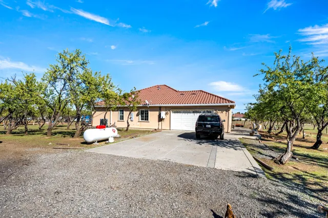 a view of a house with backyard and sitting area