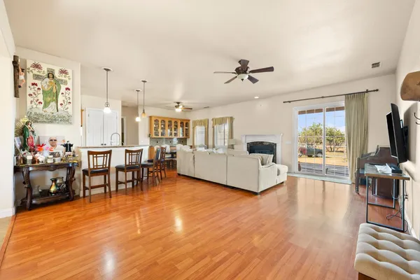 a kitchen with stainless steel appliances granite countertop a stove top oven a sink dishwasher and a refrigerator with wooden floor