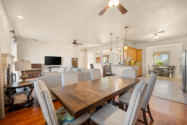 a dining room with wooden floor a chandelier a wooden table and chairs