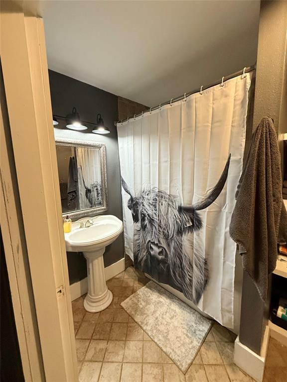203 Bennett Street Strawn, TX 76475 - Photo 16 of 28 a bathroom with a sink a toilet and a mirror