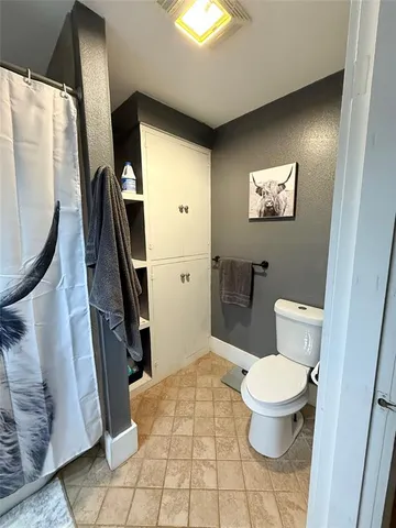 a bathroom with a toilet and a mirror