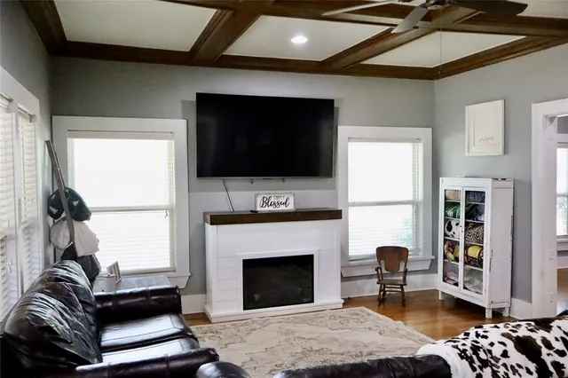 a living room with furniture a flat screen tv and a fireplace