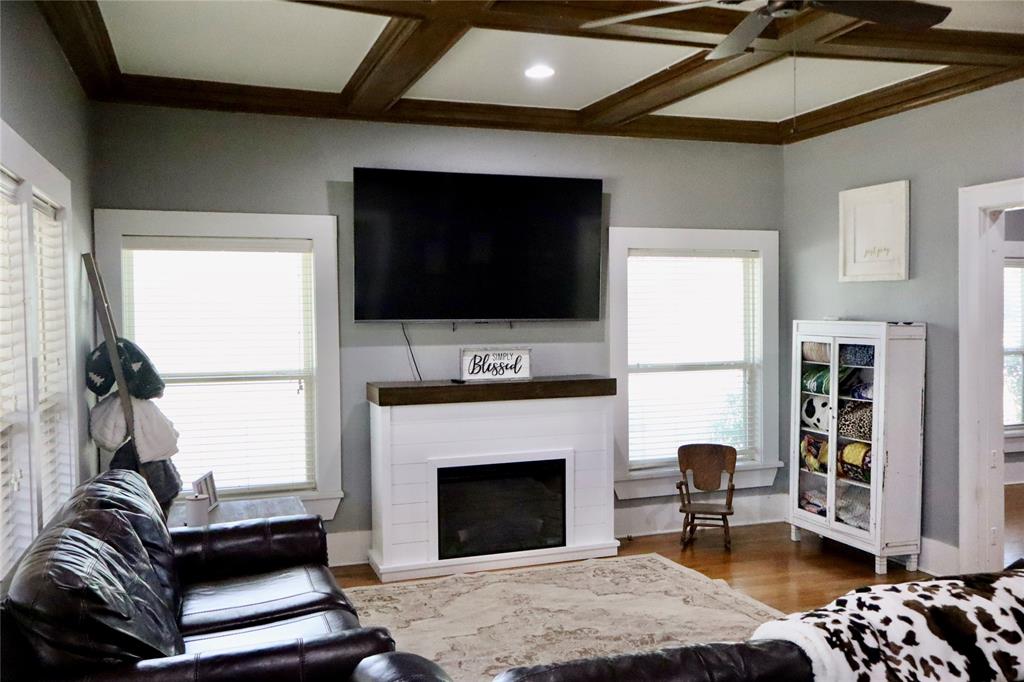203 Bennett Street Strawn, TX 76475 - Photo 2 of 28 a living room with furniture a flat screen tv and a fireplace