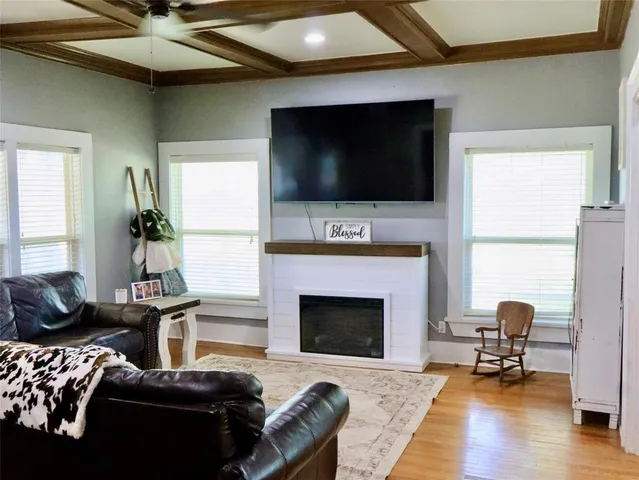 a living room with furniture a flat screen tv and a fireplace