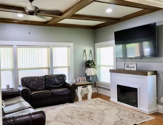 a living room with furniture a flat screen tv and a fireplace